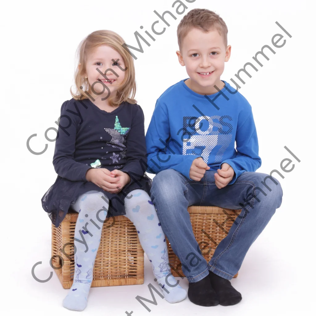 Ein Mädchen und ein Junge sitzen auf zwei Hocker